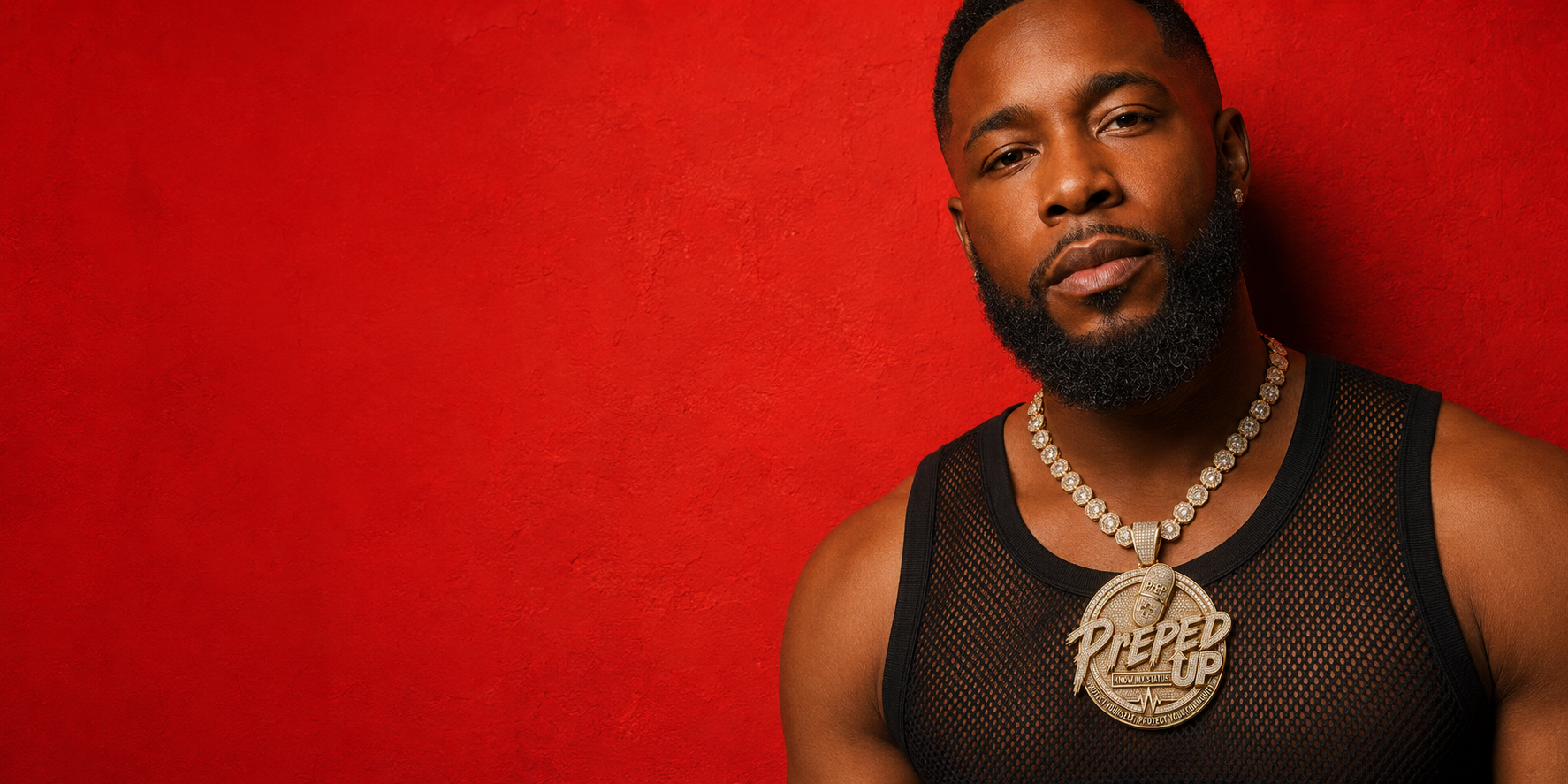 Man wearing a chain necklace and an End It Atlanta tank top in front of a red brick wall